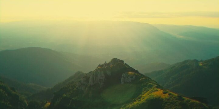 Aerial cinematic view of rocky mountain peaks near Tiganesti refuge in Bucegi Mountains at sunset
