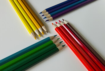 Vibrant, colorful pencils are arranged on a white background. Education and art supplies concept with copy space.