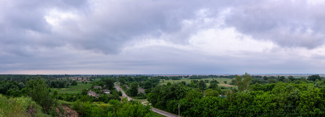 A cloudy dawn gently unfolds over a picturesque village in the Poltava region of Ukraine, casting a...