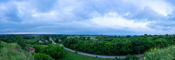 A cloudy dawn gently unfolds over a picturesque village in the Poltava region of Ukraine, casting a...