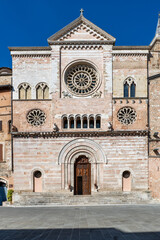 medieval facade of Foligno Cathedral, Umbria, Italy, with intricate rose windows and arched entrance, set on the main square. A popular tourist spot near Perugia
