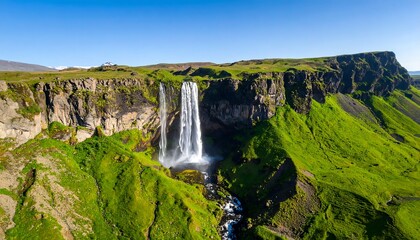 Obraz premium Panoramic view of cascading waterfalls in a lush green valley
