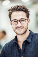 Obraz premium Portrait of smiling young male office worker wearing eyeglasses