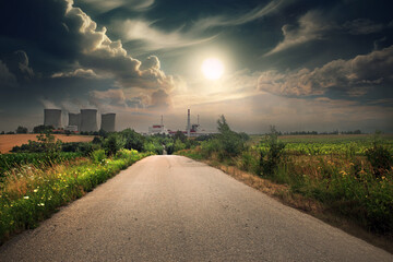 Nuclear power plant in the landscape at sunset with tall cooling towers