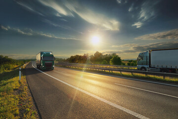 Large Transportation Truck on a highway road through the countryside at sunset
