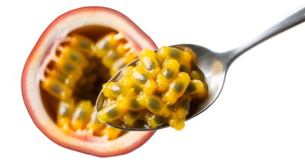 Passion fruit seeds sit on spoon, half passion fruit shows pulp, on black background