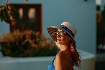 Woman in Blue Dress and Hat in Sunny Mediterranean Garden

A woman in a vibrant blue dress, striped...