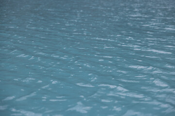 Water surface close up, calm lake in swiss mountains, water with reflections, wind