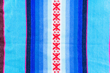 Colorful hand-woven Inca textile background with ancient designs from the Andes mountain range of...