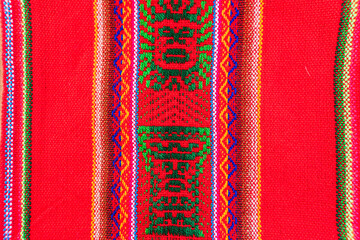 Colorful hand-woven Inca textile background with ancient designs from the Andes mountain range of...