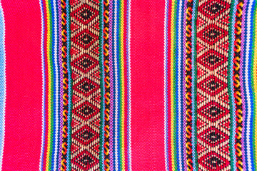 Colorful hand-woven Inca textile background with ancient designs from the Andes mountain range of...