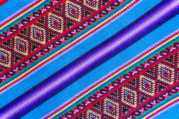 Colorful hand-woven Inca textile background with ancient designs from the Andes mountain range of...
