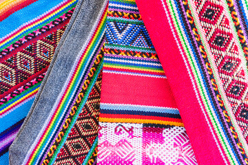 Colorful hand-woven Inca textile background with ancient designs from the Andes mountain range of...