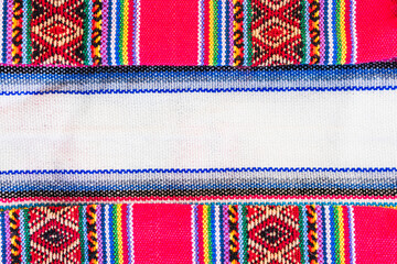 Colorful hand-woven Inca textile background with ancient designs from the Andes mountain range of...