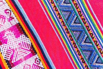 Colorful hand-woven Inca textile background with ancient designs from the Andes mountain range of...