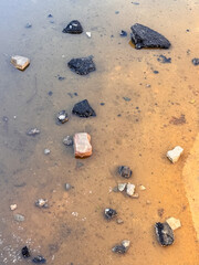 Rocks And Asphalt Fragments Scattered in Muddy Water