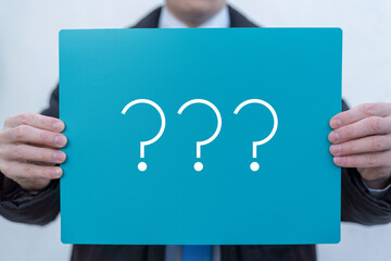 Business person holding turquoise banner with question marks. Questions Problem Solution Confusion...