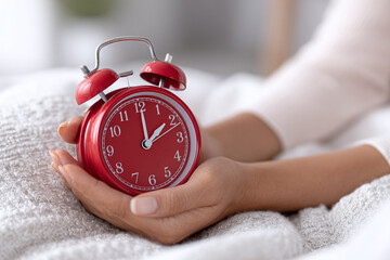 hand holding alarm clock on blank background, copy space