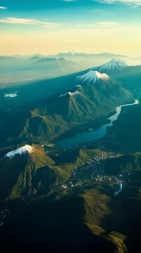 Snow-Capped Volcanoes and Lush Valleys at Sunrise &ndash; Aerial View