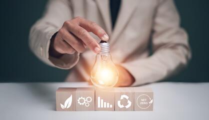 Renewable resource concept to reduce costs environmental sustainability. Hand holding lightbulb on...