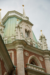 Obraz premium High roof view of the royal old palace in the park in Moscow city under with windows and arches on summer day blue sky. Closeup