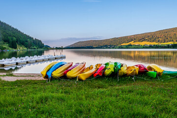 Colorful Kayaks and Pedal Boats on the Shore of  lake at Sunset in France.
