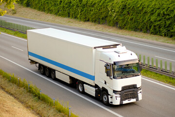 White Modern Sustaianble Refrigeration Transporter, Euro Semi Truck on Highway Near Forest – Fast...