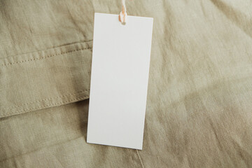 Natural linen cloth with white paper price tag. Blank mockup template of label tag card with copy...