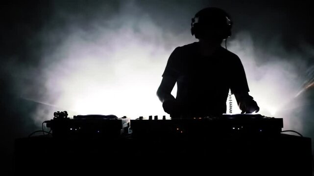 Silhouette of Male DJ Performing With Lights