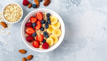 Top View of Oatmeal Bowl with Assorted Fresh Fruits and Almonds on Grey Table