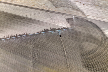 Aerial view of irrigation system watering farm field during dry season. Industrial sprinkler...