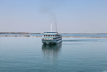 Passenger ship arriving at the port on a calm sunny day
