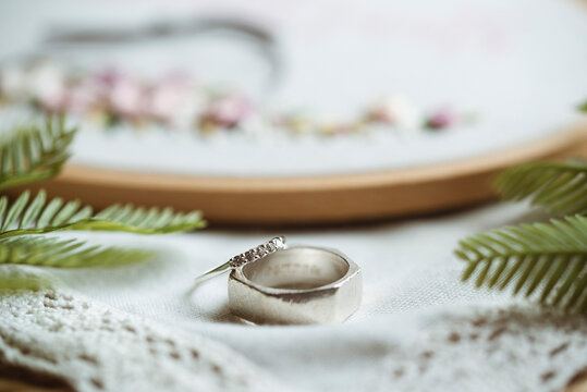Close-Up of two wedding rings next to an embroidery hoop
