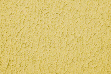 Close up of textured yellow color painted wall with rough stucco, plaster wall texture. Vibrant background, wallpaper, backdrop, design element.
