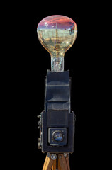 Antique camera with large bulb against black background and dramatic lighting