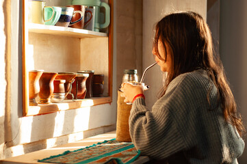 mujer bebiendo mate en la mañana. joven disfrutando un mate en la mañana.
