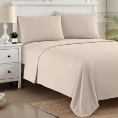 Soft beige bed linens on a neatly made bed in a cozy bedroom setting perfect for relaxation and comfort.
