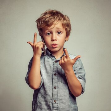 boy pretending to talk on phone with hand gesture fun and imaginative sharp detail neutral background