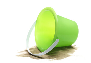 Plastic green bucket, beach toy for kids in sand, isolated on white background