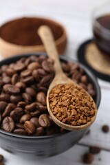 Roasted beans and granulated instant coffee on white wooden table, closeup