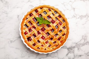 Tasty cherry pie on white marble table, top view