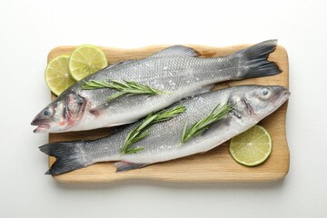 Fresh raw seabass with spices on white table, top view. Fish and seafood delicacies