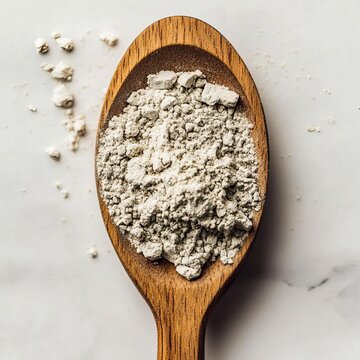 closeup of arrowroot powder in wooden spoon white fine texture macro food additive detail clean studio setup