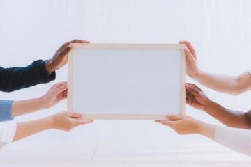 Diverse hands holding an empty whiteboard for message or collaborative effort