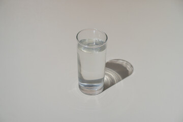Clear glass of drinking water casting a soft shadow