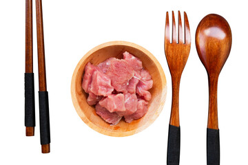 raw meat on a wooden bowl with fork and spoon