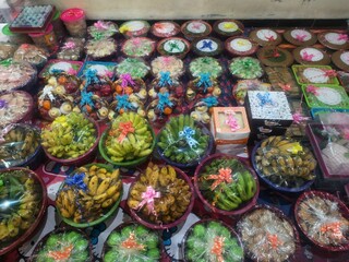 Assorted Fruits and Traditional Sweets in Decorative Packaging, Display of Festive Food Gifts...