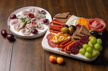 Traditional meal with dumplings and assorted cured meats on rustic table
