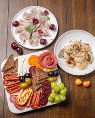 Traditional meal with dumplings and assorted cured meats on rustic table