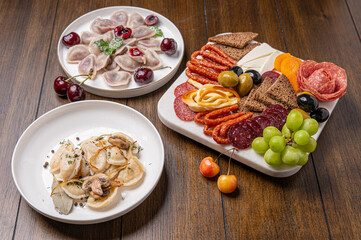 Traditional meal with dumplings and assorted cured meats on rustic table